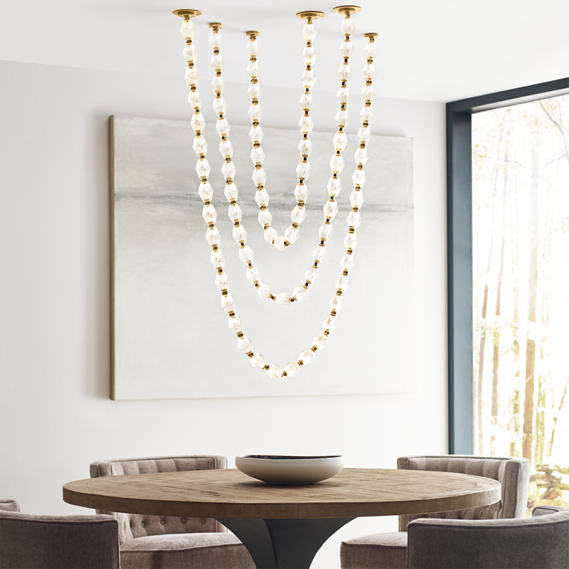 The Collier 108 Chandelier from Visual Comfort and Co in natural brass in a dining room.