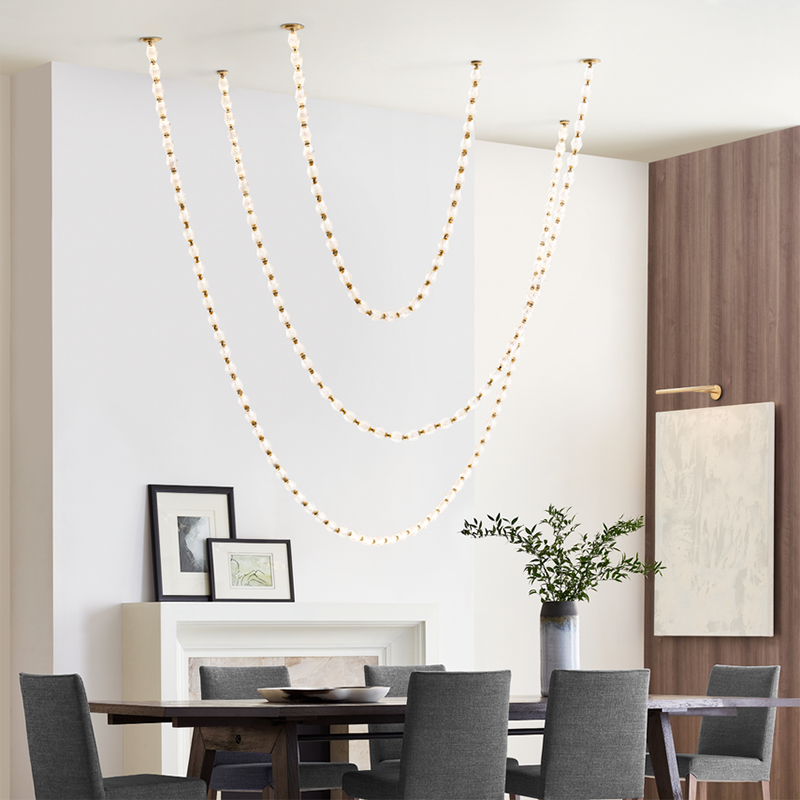 The Collier 108 Chandelier from Visual Comfort and Co in natural brass in a dining room.
