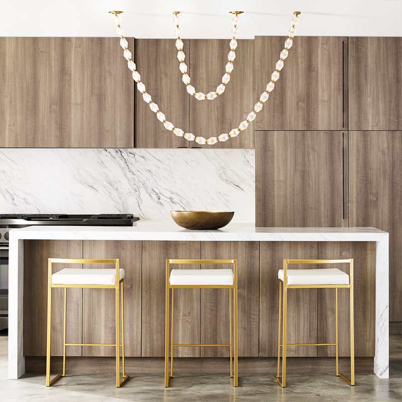 The Collier 84 Chandelier from Visual Comfort and Co in natural brass over a kitchen island.