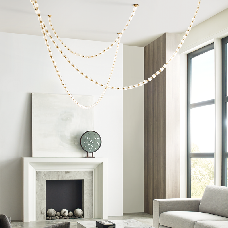 The Collier 84 Chandelier from Visual Comfort and Co in natural brass in a living room.