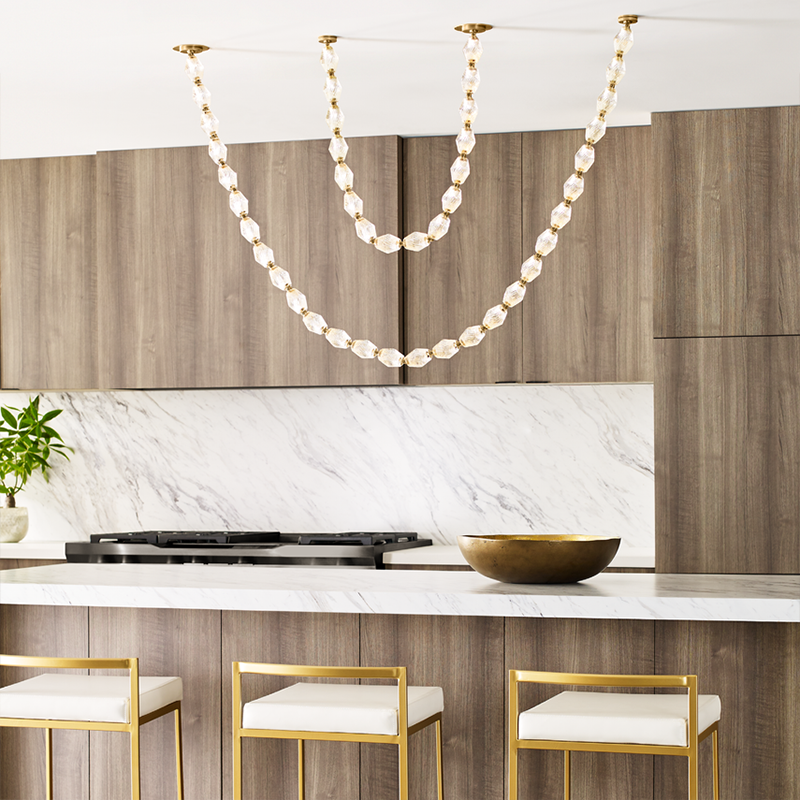 The Collier 84 Chandelier from Visual Comfort and Co in natural brass in kitchen with island