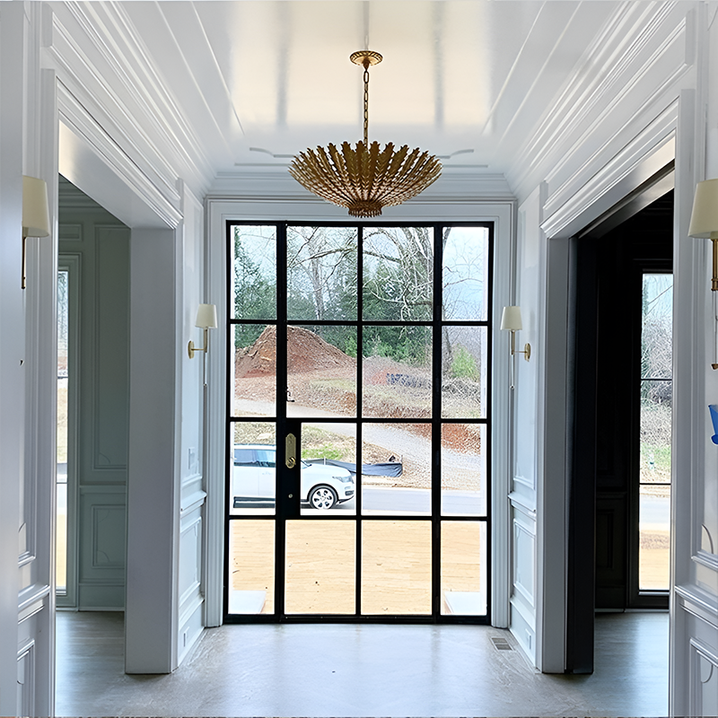 The Hampton Medium Chandelier from Visual Comfort and Co in antique gold in a living room.