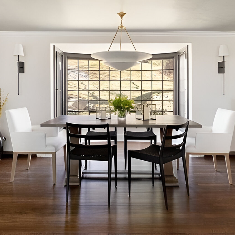 The Mollino Large Tiered Chandelier from Visual Comfort and Co in hand-rubbed antique brass in a dining room.