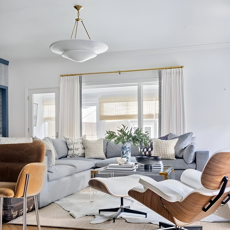 The Mollino Large Tiered Chandelier from Visual Comfort and Co in hand-rubbed antique brass in a lounge.