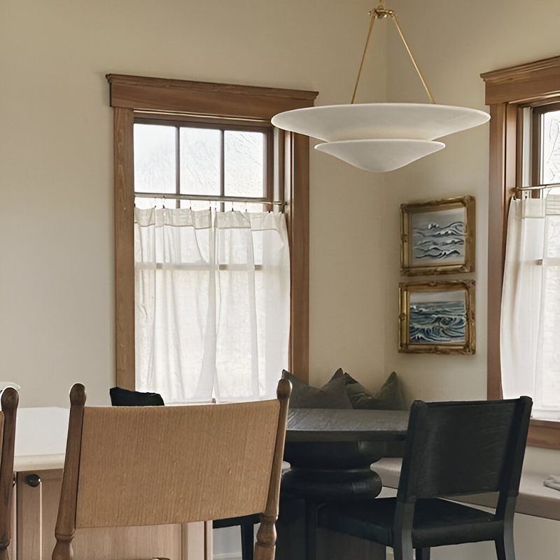 The Mollino Large Tiered Chandelier from Visual Comfort and Co in hand-rubbed antique brass in a breakfast nook.