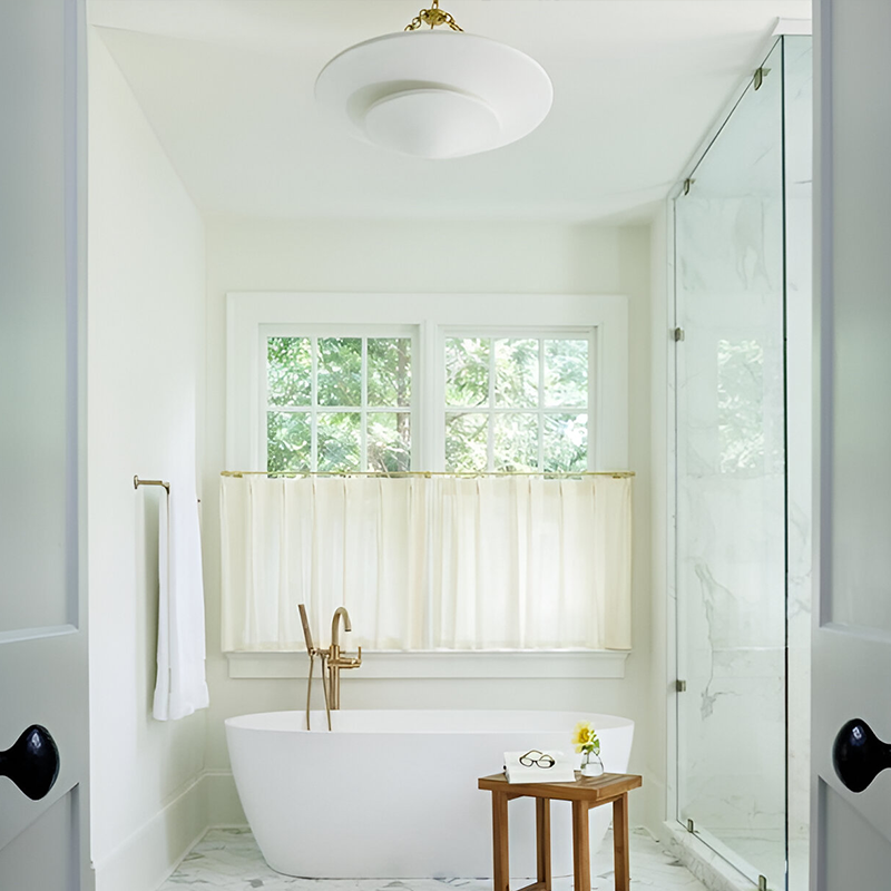 The Mollino Medium Tiered Chandelier from Visual Comfort and Co in hand-rubbed antique brass in a bathroom.