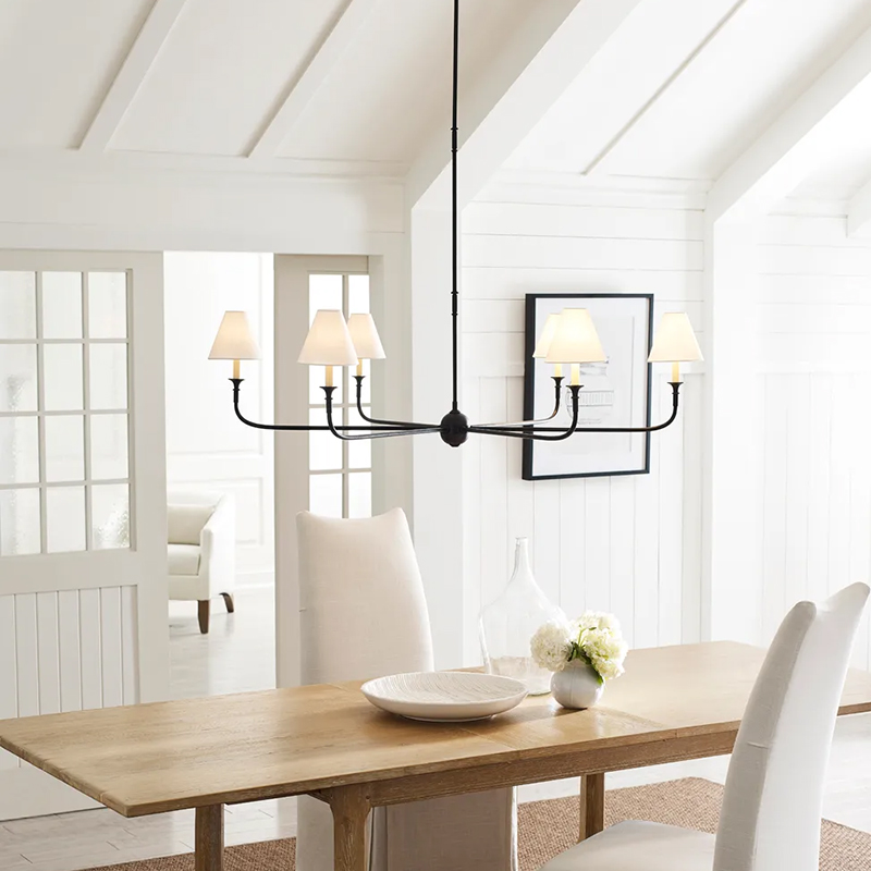 The Piaf Grande Chandelier from Visual Comfort & Co. in aged iron and ebonized oak in a dining room.