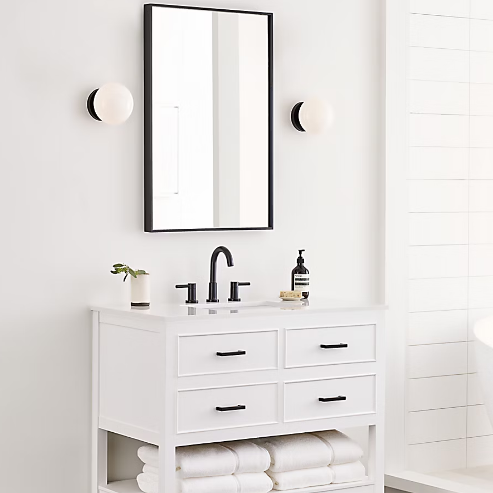 The Lune 1-Light Bath Sconce from Visual Comfort & Co in Aged Iron in a bathroom.