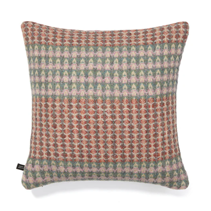 The Bryce Cushion by Wallace & Sewell. Made of 100% Shetland Wool. Cushion with muted sage green, orange, and red tones.
