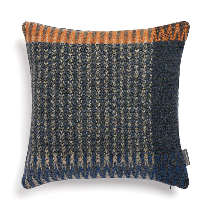 The Cairngorm Shetland Tweed Cushion is a textured pillow with orange and blue pattern.