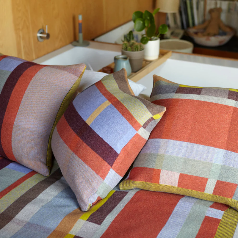 The Cecil Cushion with matching throw on a bed.