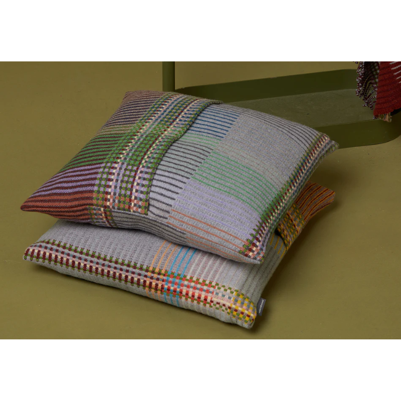 The Joan Cushion by Wallace & Sewell stacked on the floor.