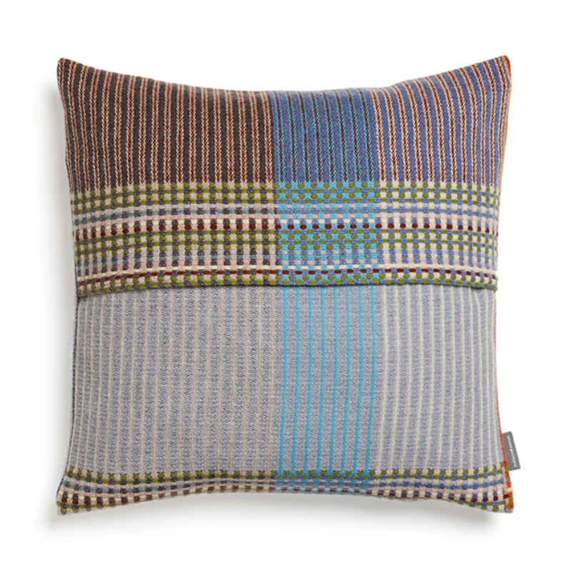 The Joan Cushion by Wallace & Sewell has light grey, burnt sienna, mossy green and highlights of pale yellow and blush sprinkled throughout.