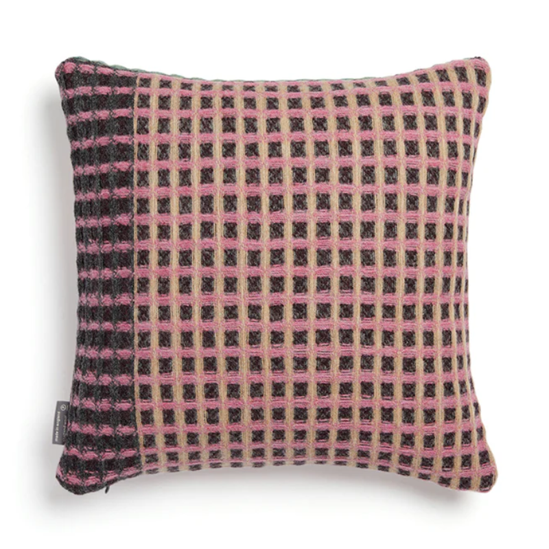 The Kew Cushion by Wallace and Sewell is made of natural shetland wool. Pink and Gray accents.