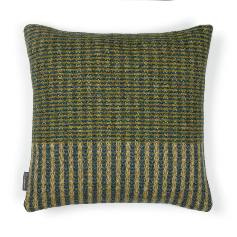 The Lismore Cushion by Wallace & Sewell features a blend of woven green natural fibers.