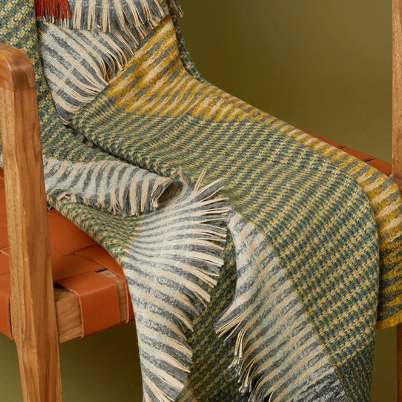 The Lismore Throw by Wallace & Sewell draped on a chair.
