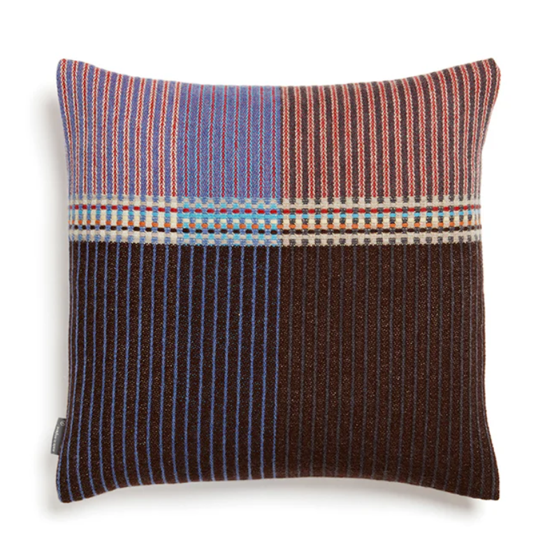 Wallace & Sewell's Pinstripe Sophia cushion features a dark color palette contrasted by vibrant purples and reds.