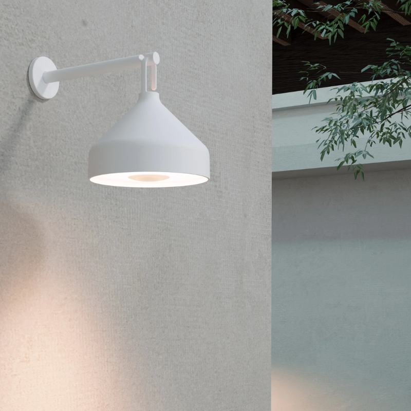 The white Amelie Pro Wall Lamp from Zafferano outdoors in a garden. all-groups