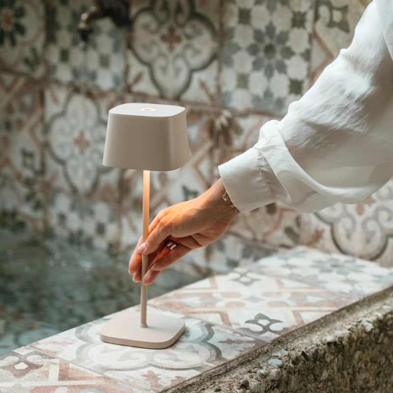 The sand Ofelia Pro cordless lamp from Zafferano in a hallway.