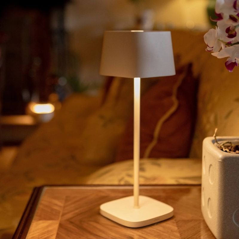 The white Ofelia Pro cordless lamp from Zafferano in a primary bedroom.