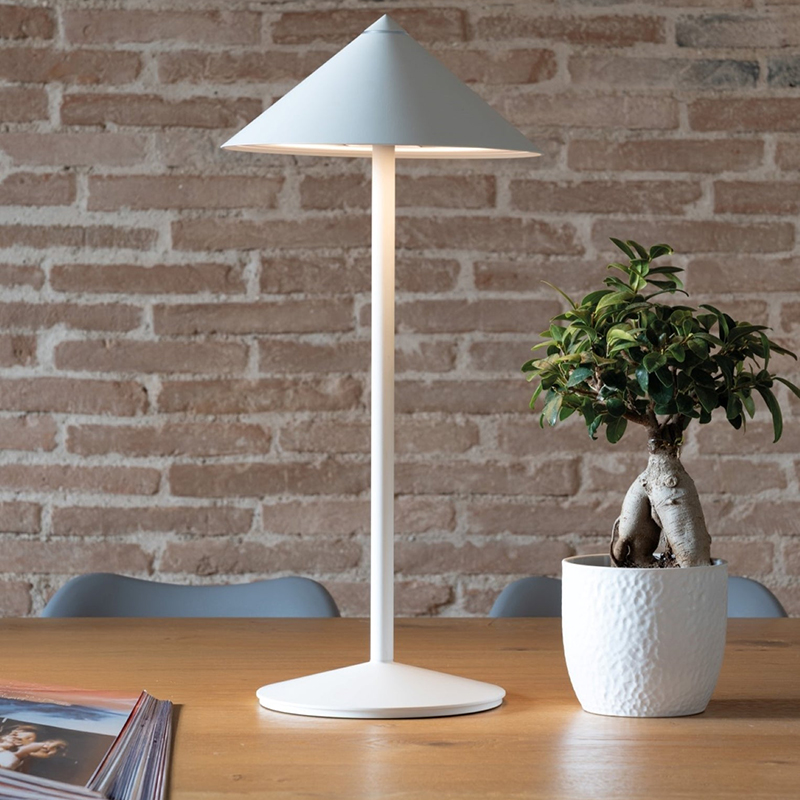 The white Pina L Desk Lamp from Zafferano in a living room.
