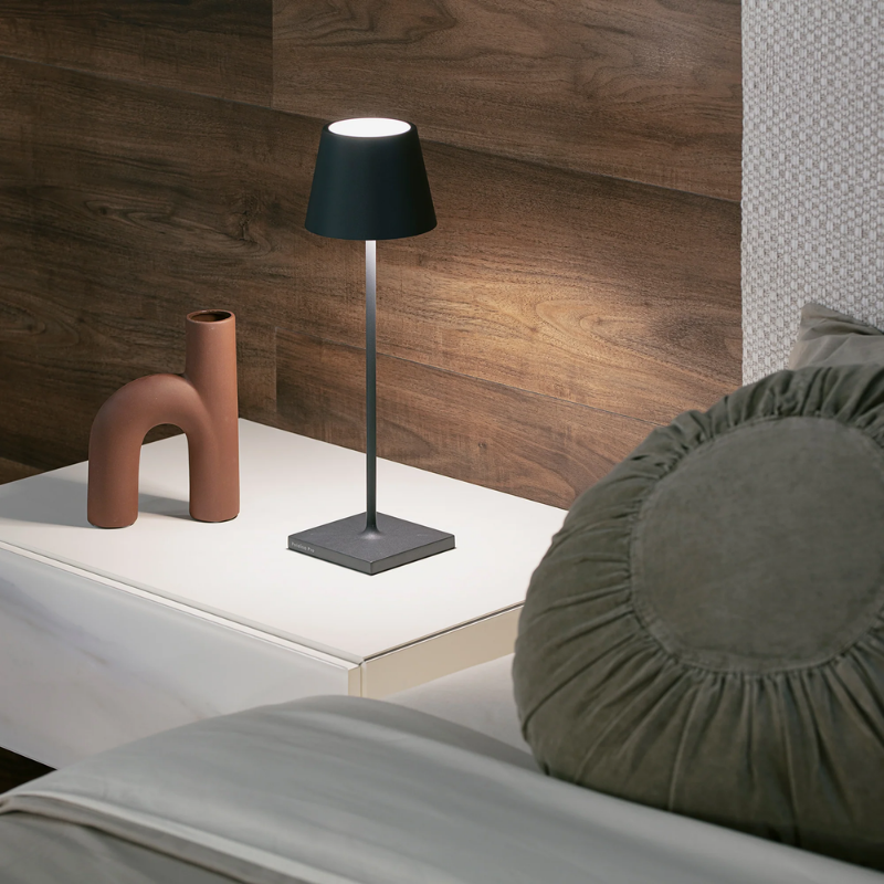 The dark gray Poldina Pro from Zafferano on a bedside table.