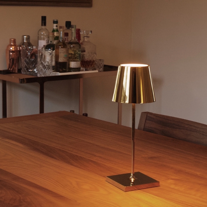 The glossy gold Poldina Pro Mini from Zafferano on a dining table.