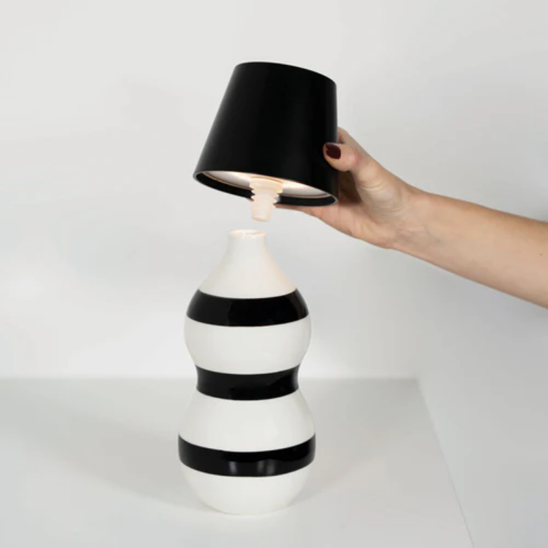 The black Poldina Pro Stopper from Zafferano being placed into a bottle.