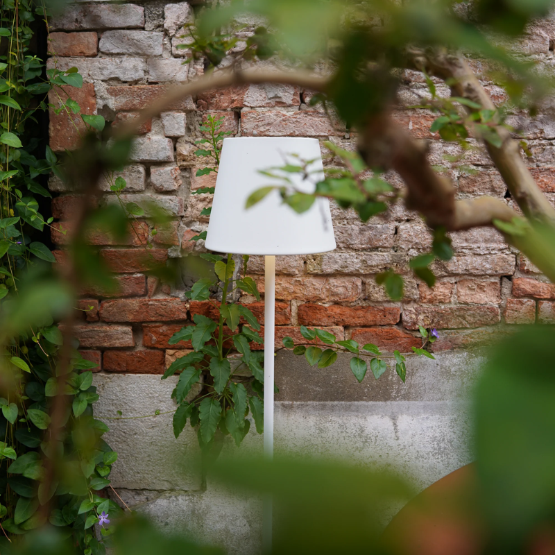 The white Poldina Pro XXL Floor Lamp from Zafferano outdoors.