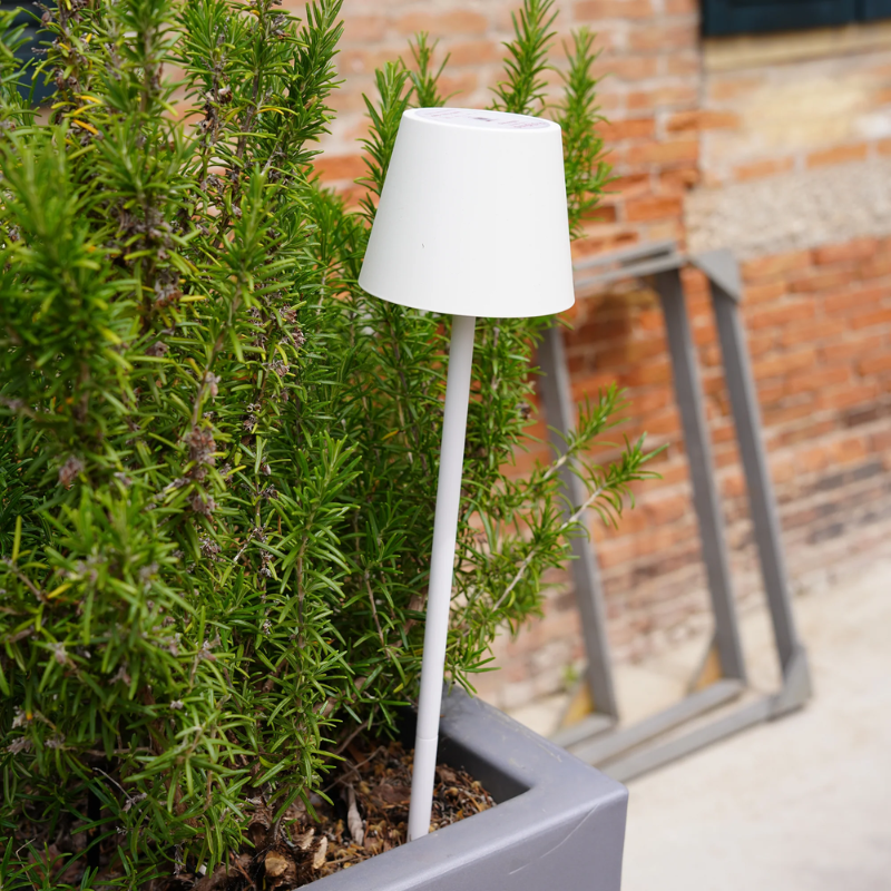 The white Poldina Pro Peg Magnetic from Zafferano outdoors in a cafe garden.