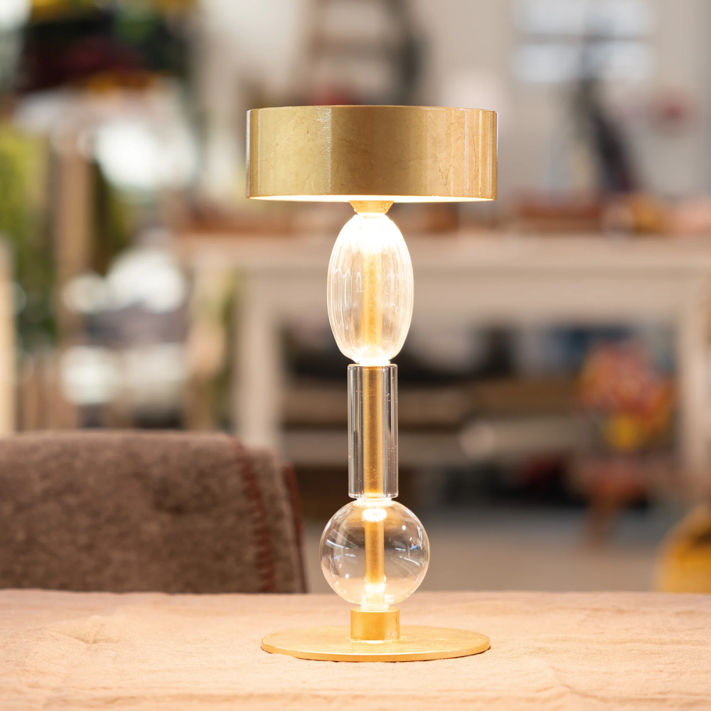 The golf leaf with clear glass Royal Family Wi-Fi Table Lamp from Zafferano in a family area.