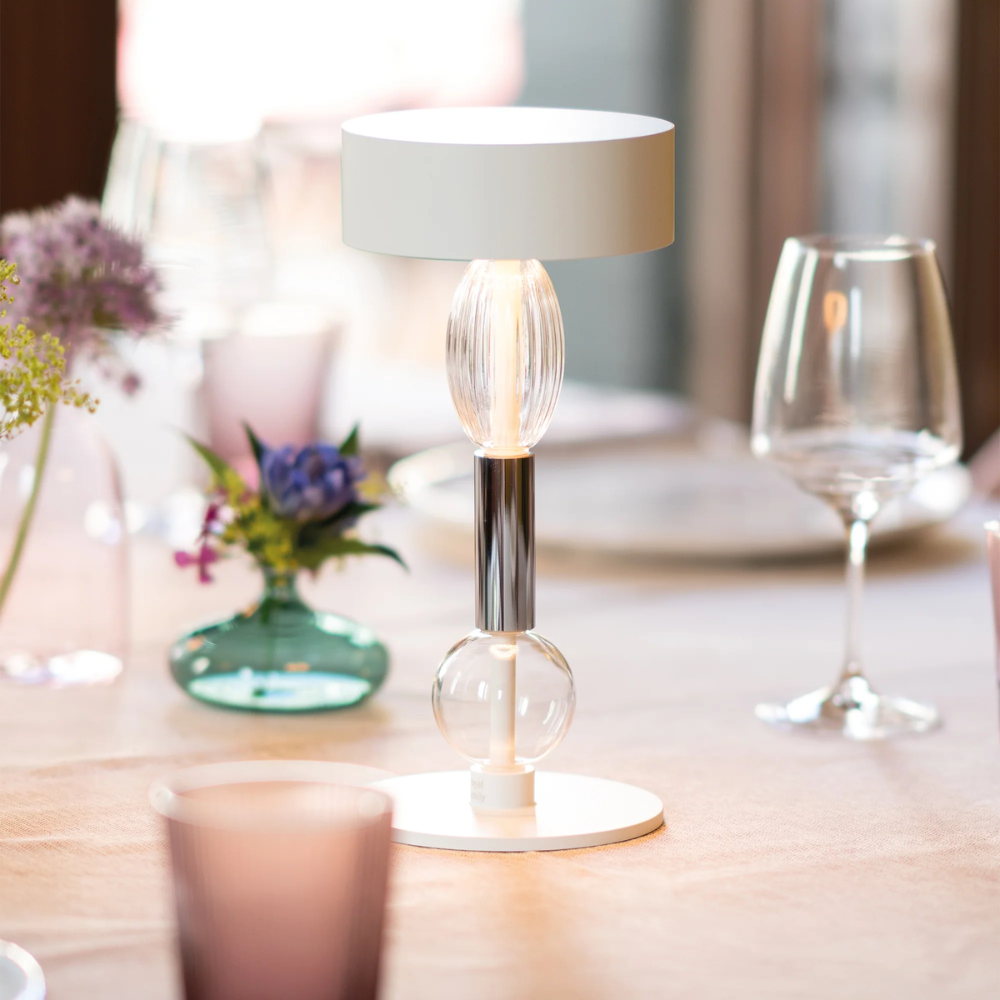 The white with clear and gray glass Royal Family Wi-Fi Table Lamp from Zafferano in a dining room.