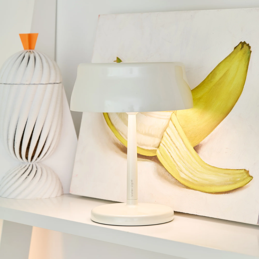 The white Sister Light Mini Wi-Fi Table Lamp from Zafferano in a lounge.