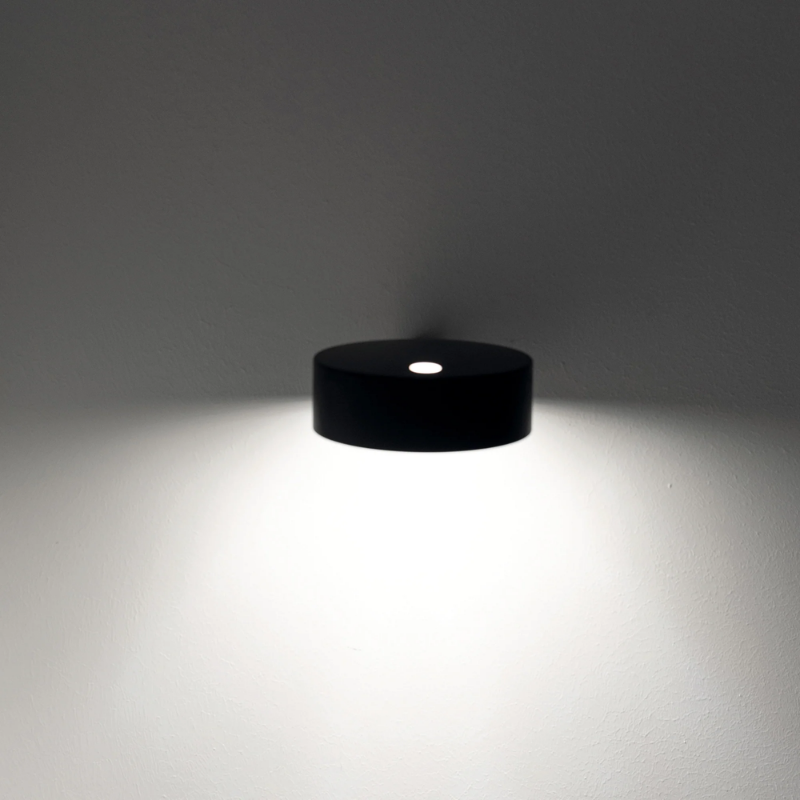 The black Super O Wall Spotlight from Zafferano lighting from down below.