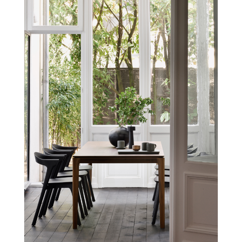 The Bok Dining Table from Ethnicraft in a room looking out into the garden.