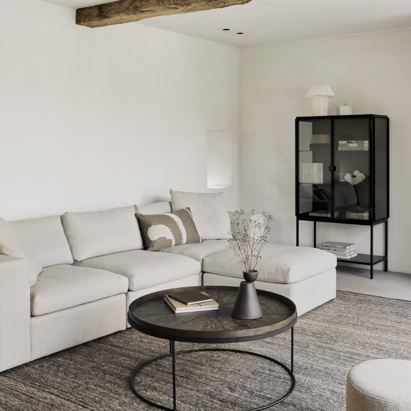 The Mellow End Seater from Ethnicraft in a modern living room with a coffee table and a black shelving unit.