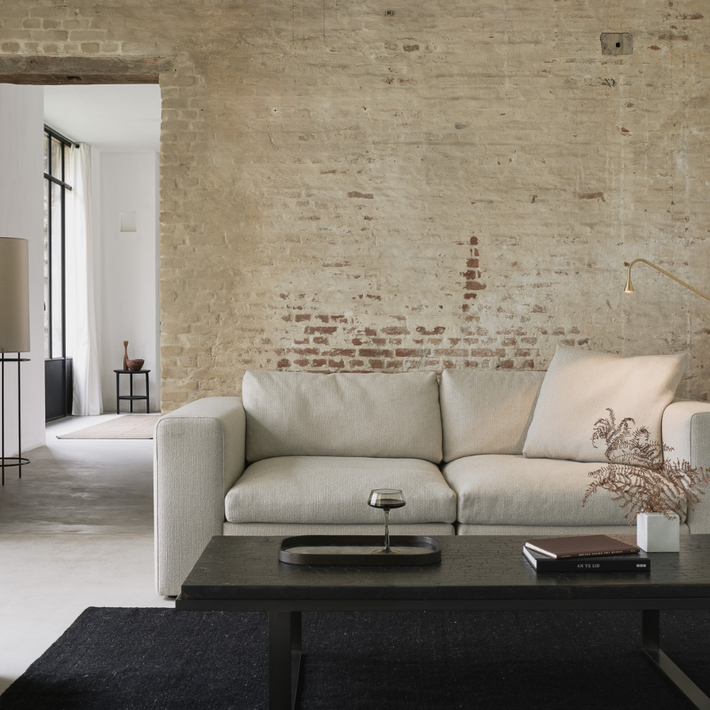 The Mellow End Seater from Ethnicraft in modern living space against a brick wall.