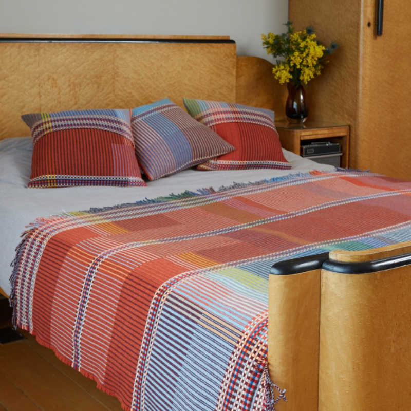 The Beatrix Throw by Wallace & Sewell is made of woven merino lambswool. The Pinstripe collection combines bold-colored blocks with fine, detailed vertical stripes. This double-sided design also has a contrasting pixelated border and is a stunning room addition