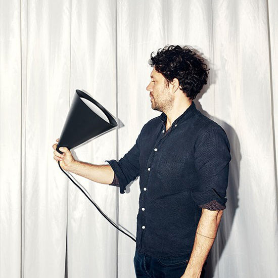 Designer Jakob Lange of BIG Ideas holds the Keglen Pendant light in Black