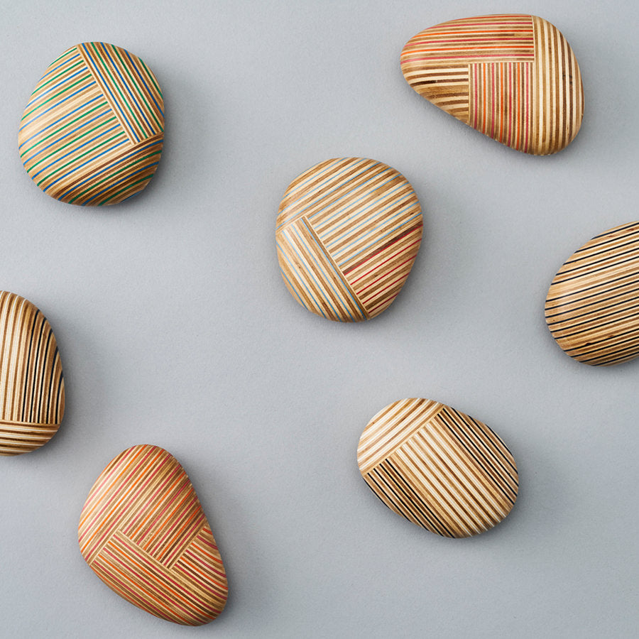 Pebble-like paperweights made by joining beautiful plywood pieces in a patchwork style. Designed by Drill Design.