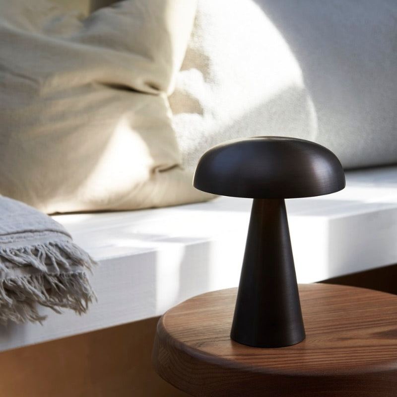 Como SC53, a portable table lamp from Space Copenhagen. Crafted from anodized aluminum, Como’s sturdy base tapers up towards a softy curved, mushroom-shaped shade. This battery-powered lamp can operate for eleven hours at the highest setting, with an extra battery option that allows additional operating. It is easily recharged with a magnetic USB cable or a charging tray.