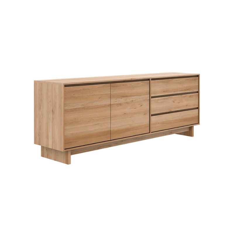 The Wave Sideboard by Ethnicraft features contoured cabinet doors and a distinguished shape to the feet. Made of solid wood, this cabinet’s doors and drawers have no handles and feature a soft closing mechanism.