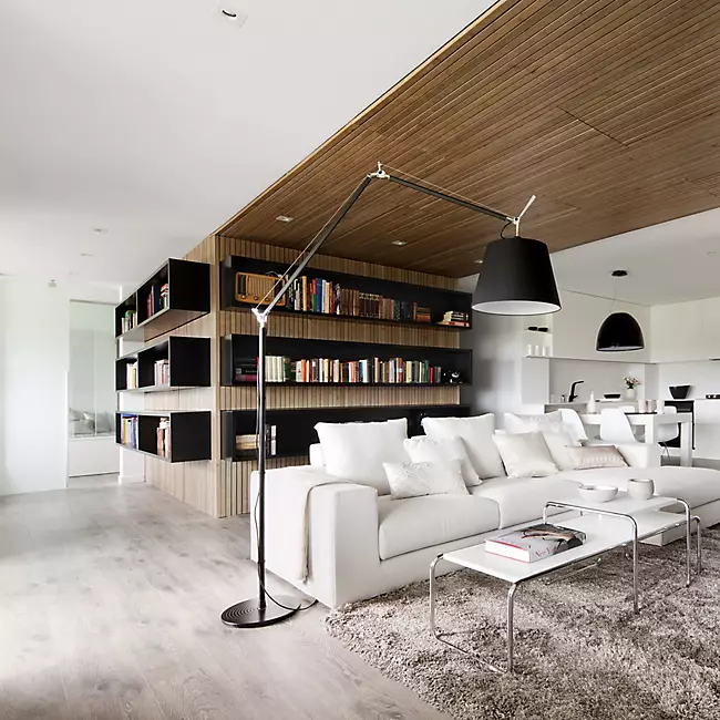 The Tolomeo Mega Floor Lamp from Artemide in black with a 17-inch shade in a family space.