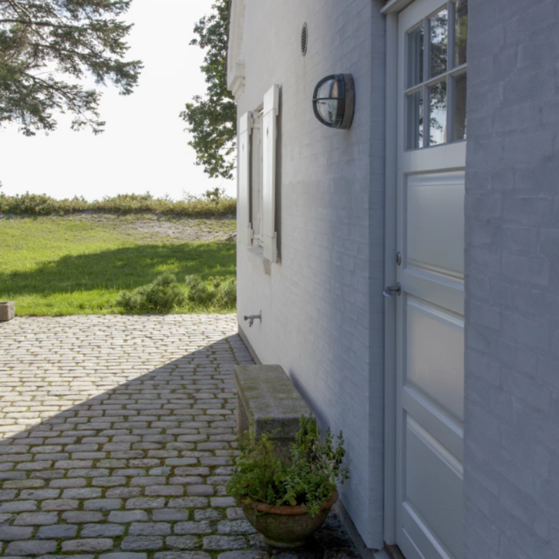 The Skot Wall from Louis Poulsen lighting up an outdoor doorway.