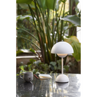 The Flowerpot VP9 Portable Table Lamp from &Tradition in a garden.
