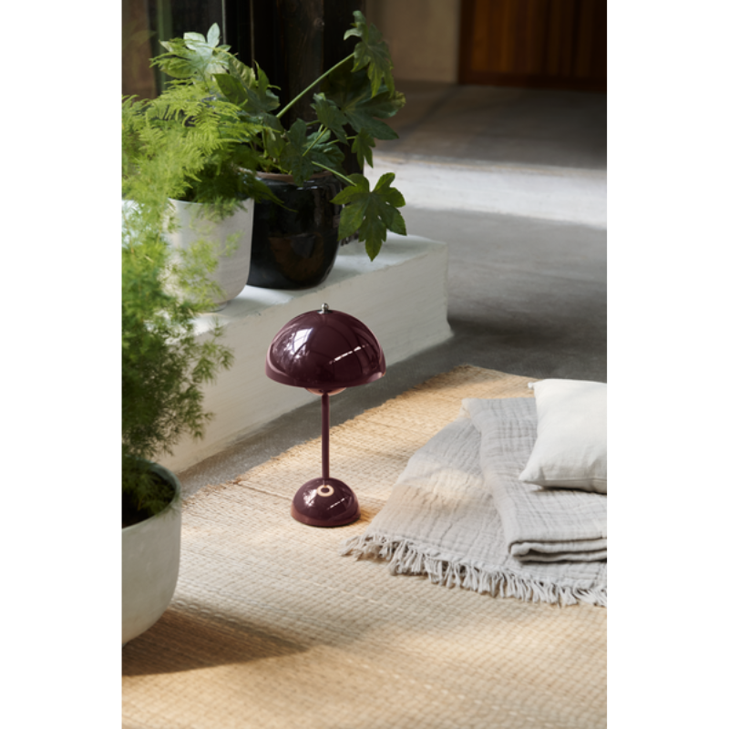 The Flowerpot VP9 Portable Table Lamp from &Tradition in a living room adorned by plants and textiles.