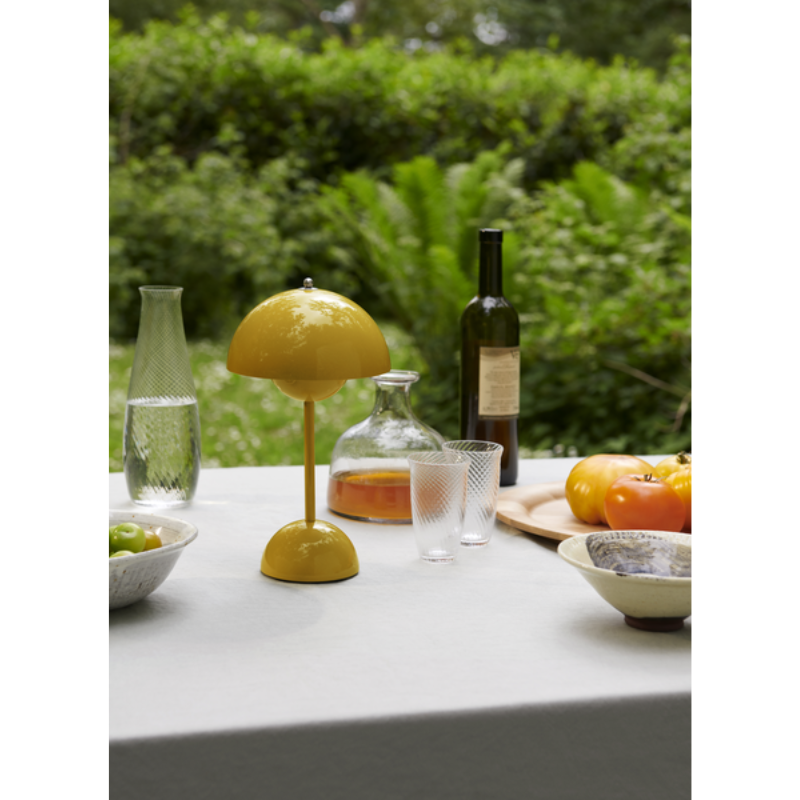 The Flowerpot VP9 Portable Table Lamp from &Tradition outdoor with wine, water and other drinks and food.