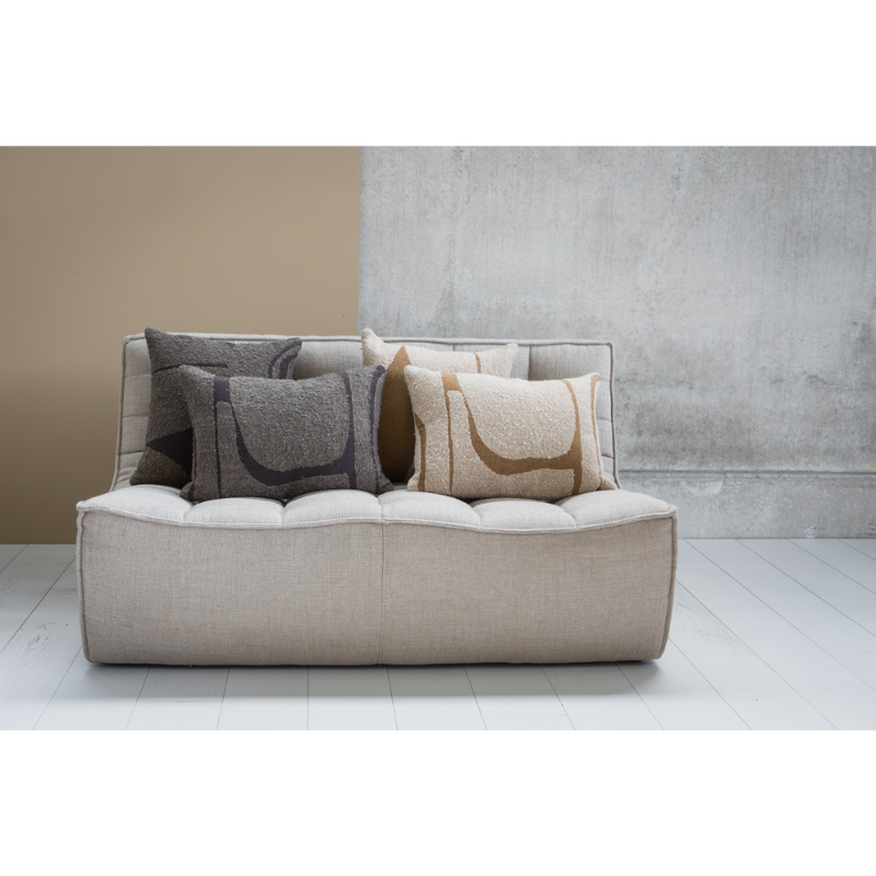 The Avana Orb Cushion from Ethnicraft in a living room lifestyle photograph.