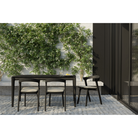 The Bok Outdoor Dining Chair from Ethnicraft within a courtyard near a sliding door.