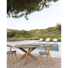 The Circle Outdoor Dining Table from Ethnicraft next to a pool with accompanying Outdoor Bok Dining Chairs.